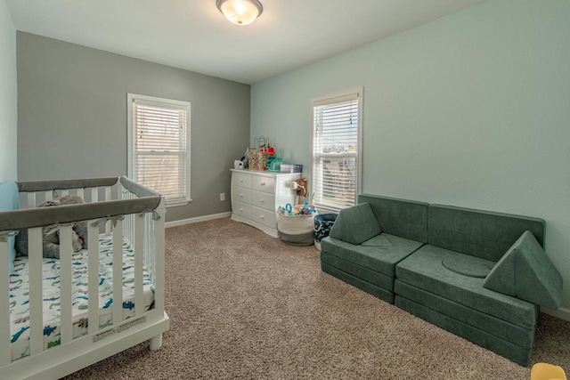 carpeted bedroom with baseboards and a nursery area