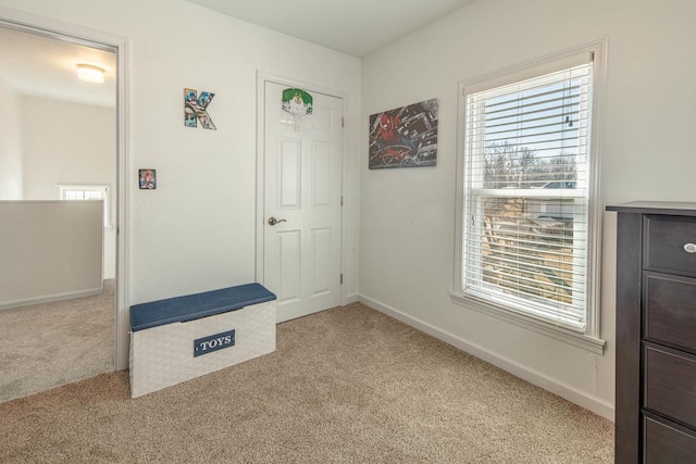 entryway featuring light carpet and baseboards