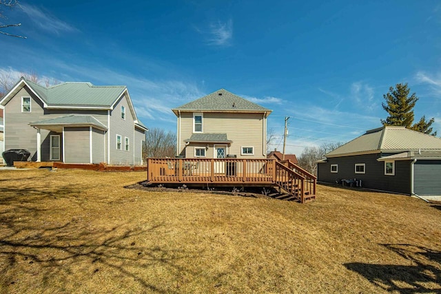 back of house featuring a lawn and a wooden deck