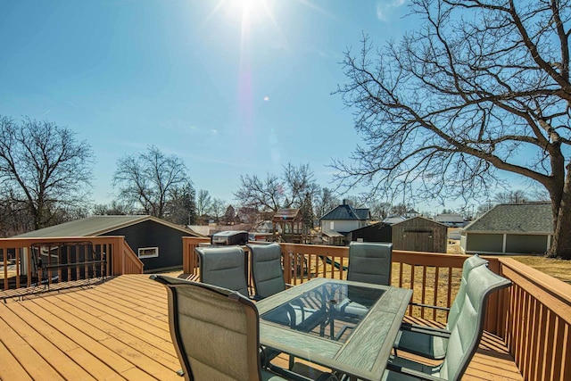 wooden deck featuring outdoor dining area and an outdoor structure