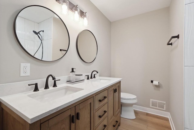 full bathroom with double vanity, visible vents, toilet, and a sink