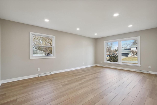 empty room featuring recessed lighting, visible vents, and light wood finished floors