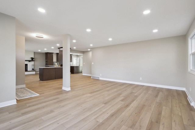 unfurnished living room with recessed lighting, visible vents, baseboards, and light wood-style flooring