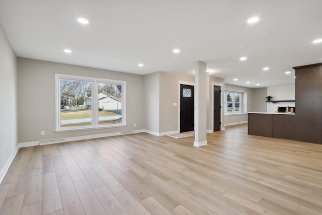 unfurnished living room featuring light wood-style flooring, recessed lighting, and a wealth of natural light