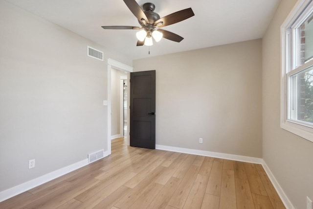 unfurnished room with light wood-style flooring, baseboards, and visible vents