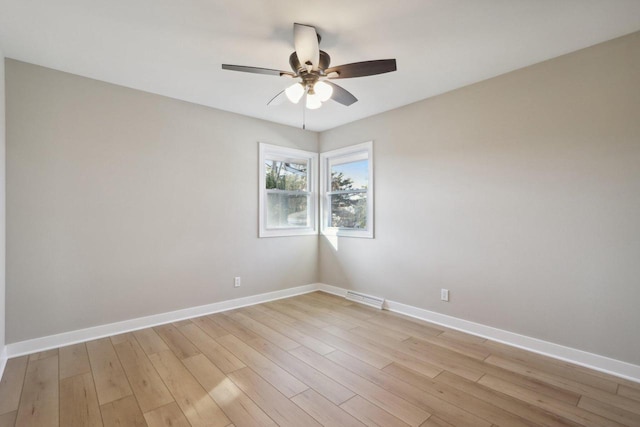 spare room with ceiling fan, visible vents, baseboards, and light wood-style flooring