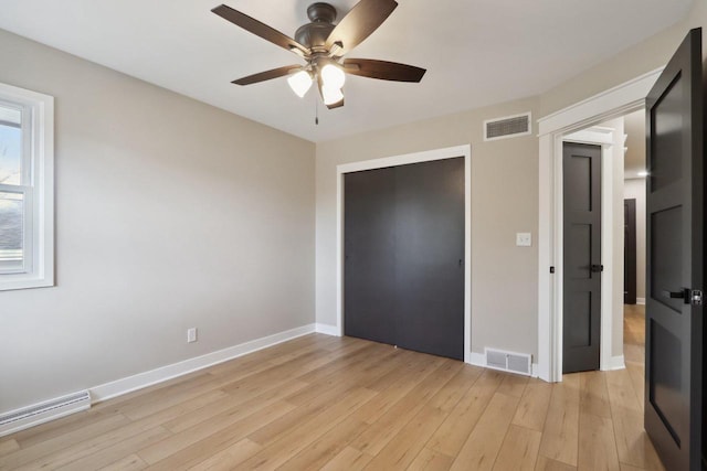 unfurnished bedroom with light wood-style floors, visible vents, and baseboards