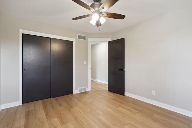 unfurnished bedroom with light wood-style flooring, baseboards, visible vents, and a closet