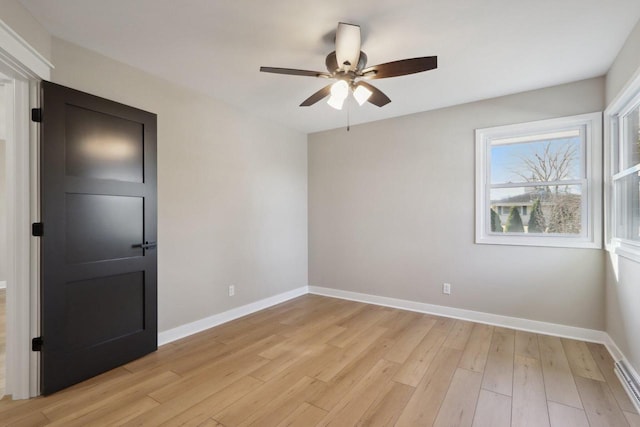 unfurnished room with ceiling fan, baseboards, and light wood-style flooring