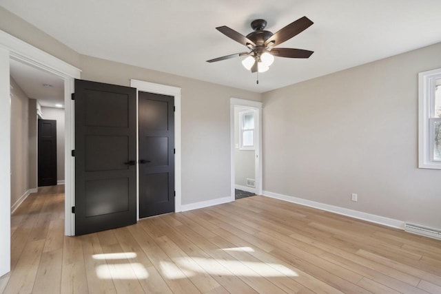 unfurnished bedroom featuring light wood-type flooring, baseboards, and a ceiling fan