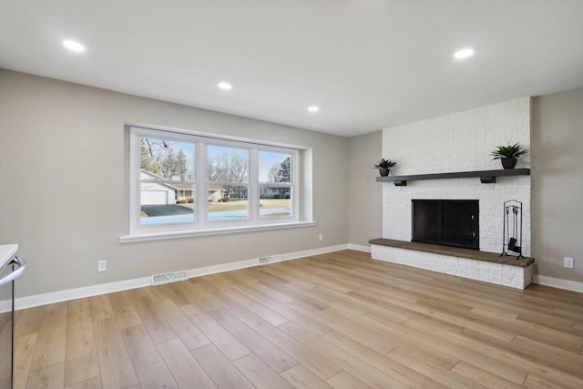 unfurnished living room featuring visible vents, baseboards, recessed lighting, a fireplace, and light wood-type flooring