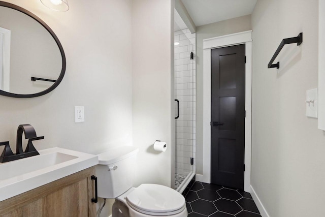 bathroom with toilet, a stall shower, tile patterned flooring, baseboards, and vanity