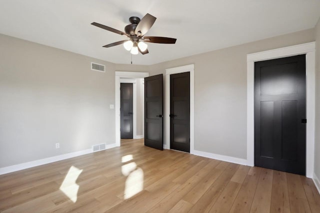 unfurnished bedroom featuring visible vents, baseboards, light wood-style floors, and a ceiling fan