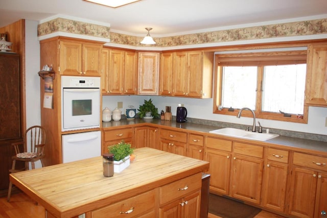 kitchen featuring white oven, a warming drawer, butcher block countertops, and a sink