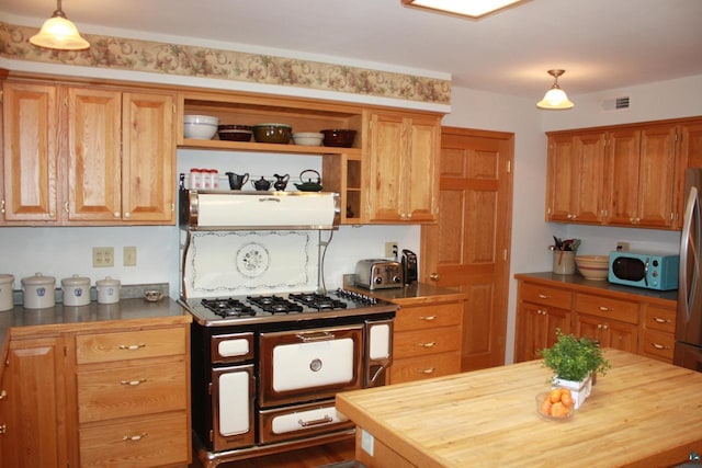 kitchen featuring visible vents, butcher block countertops, decorative light fixtures, open shelves, and range with two ovens