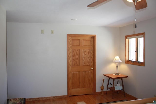 bedroom with baseboards, ceiling fan, and wood finished floors