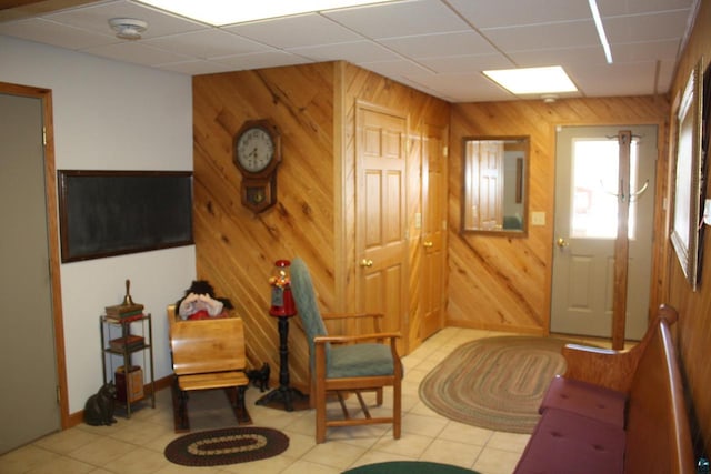 entryway with wooden walls and a drop ceiling