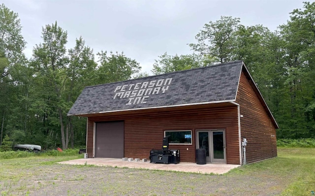 garage featuring a wooded view and driveway