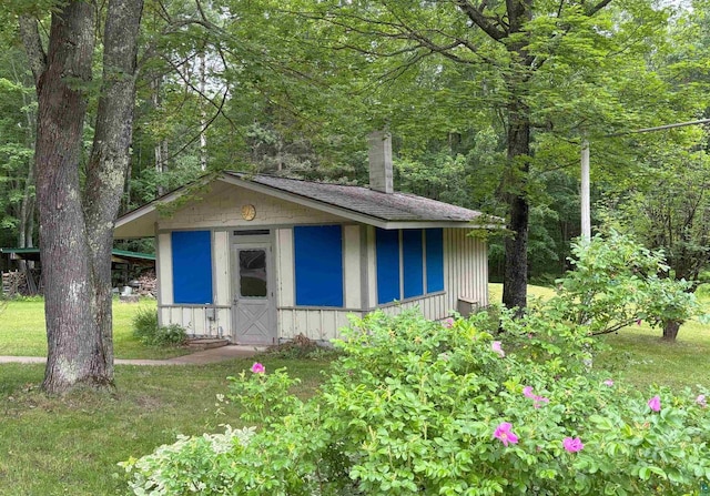 view of outdoor structure with a wooded view and an outdoor structure