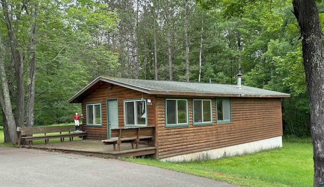 view of front facade with a wooded view and a deck