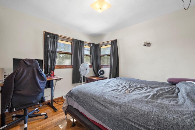 bedroom with baseboards and wood finished floors