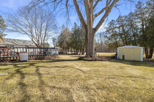 view of yard with a wooden deck, an outdoor structure, and a shed