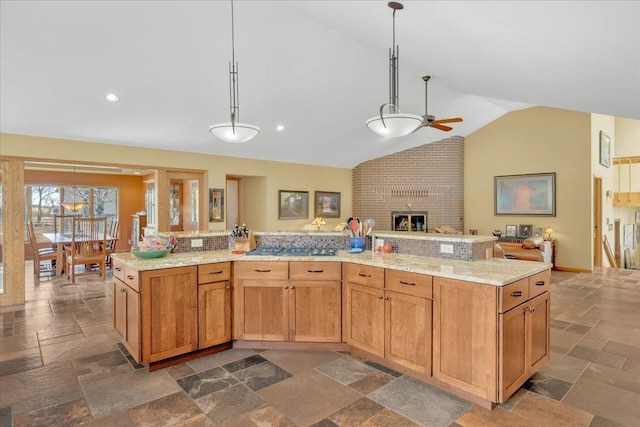 kitchen featuring a ceiling fan, lofted ceiling, stone tile flooring, decorative light fixtures, and open floor plan