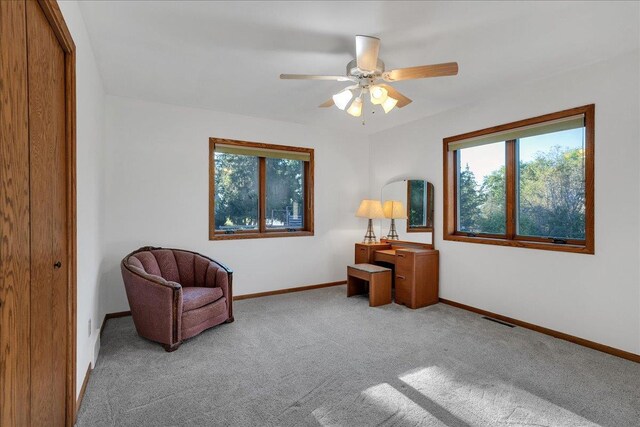 living area featuring visible vents, ceiling fan, baseboards, and carpet floors