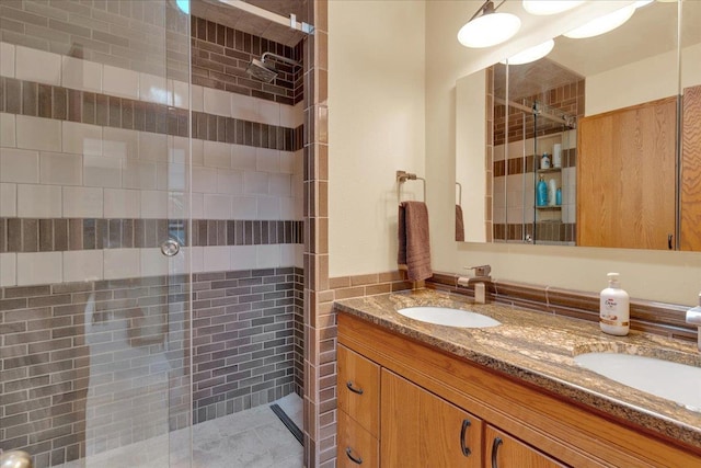 bathroom featuring a sink, double vanity, and a shower stall