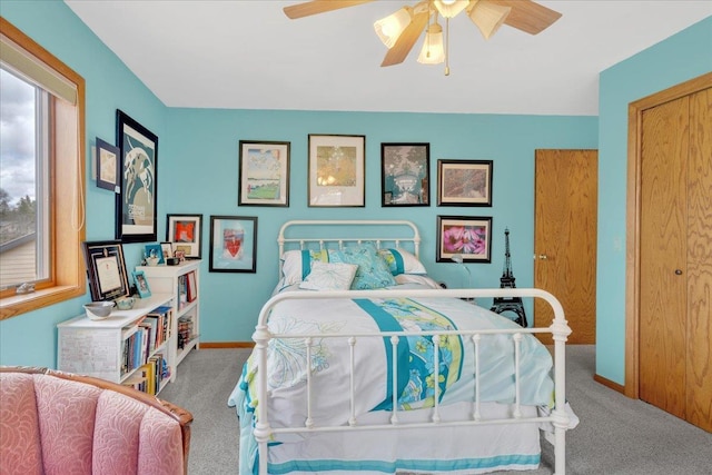 carpeted bedroom with a ceiling fan and baseboards