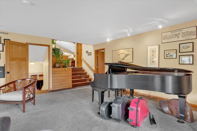 sitting room with carpet flooring, track lighting, and stairs