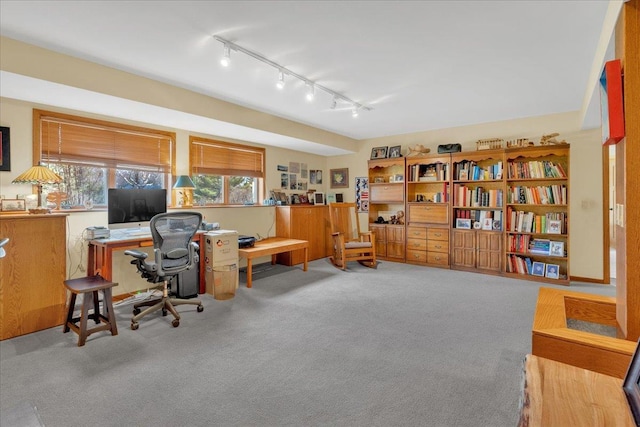 carpeted home office featuring track lighting