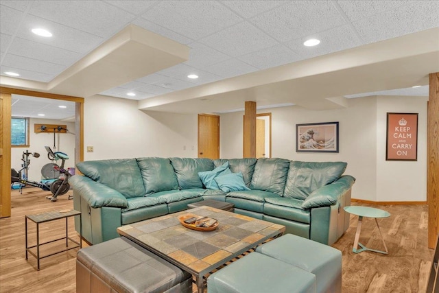 living room featuring light wood finished floors, recessed lighting, a paneled ceiling, and baseboards