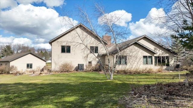 back of house with a yard and a chimney