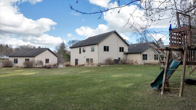 back of house featuring a playground and a yard