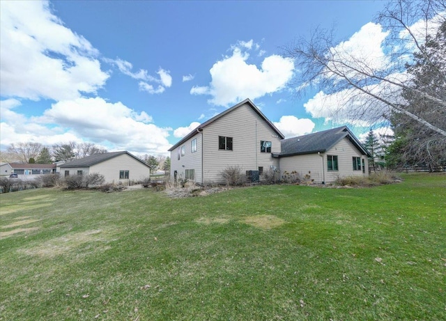 rear view of property featuring a lawn