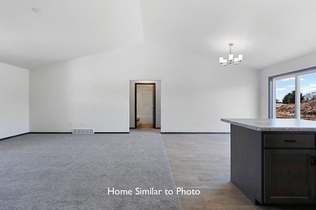 kitchen featuring lofted ceiling, a notable chandelier, baseboards, and visible vents