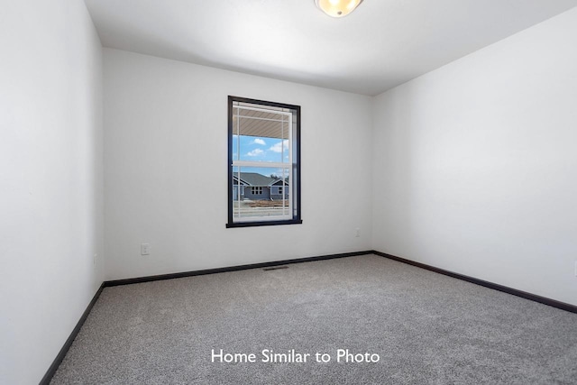 spare room featuring visible vents, baseboards, and carpet flooring