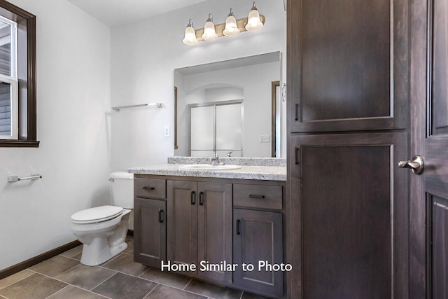 bathroom with tile patterned flooring, baseboards, toilet, vanity, and a shower