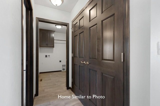 hall with light wood-style flooring and baseboards