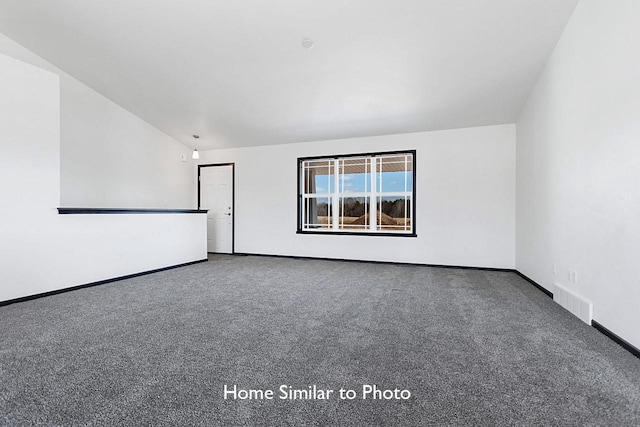 carpeted empty room featuring visible vents, baseboards, and vaulted ceiling