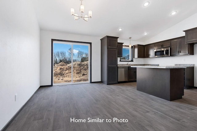 kitchen featuring dark brown cabinets, appliances with stainless steel finishes, wood finished floors, and vaulted ceiling