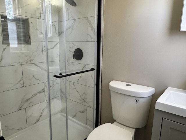 bathroom with vanity, toilet, and a shower stall