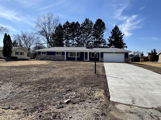 single story home with stone siding, driveway, and a garage