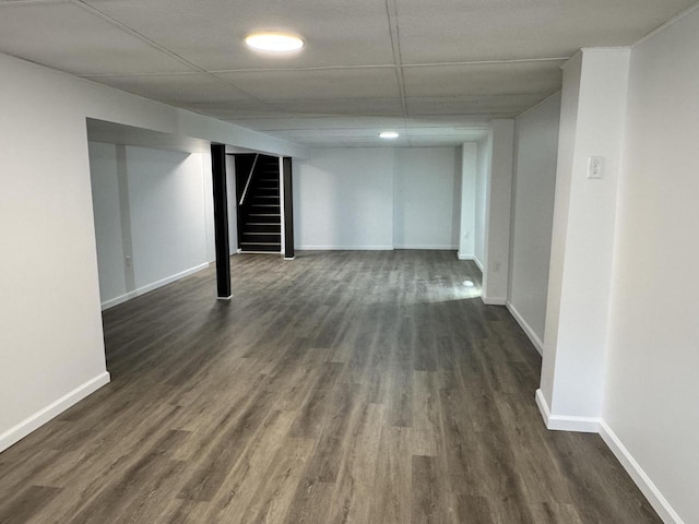 finished below grade area featuring dark wood finished floors, stairs, and baseboards