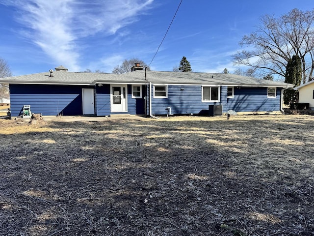 rear view of house with cooling unit and an attached garage