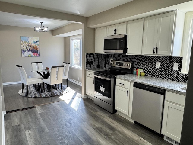 kitchen with visible vents, backsplash, appliances with stainless steel finishes, and dark wood-style flooring