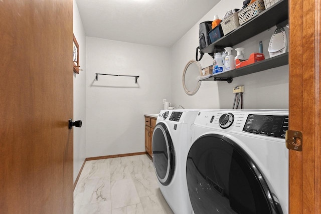 laundry area with cabinet space, marble finish floor, baseboards, and washing machine and clothes dryer