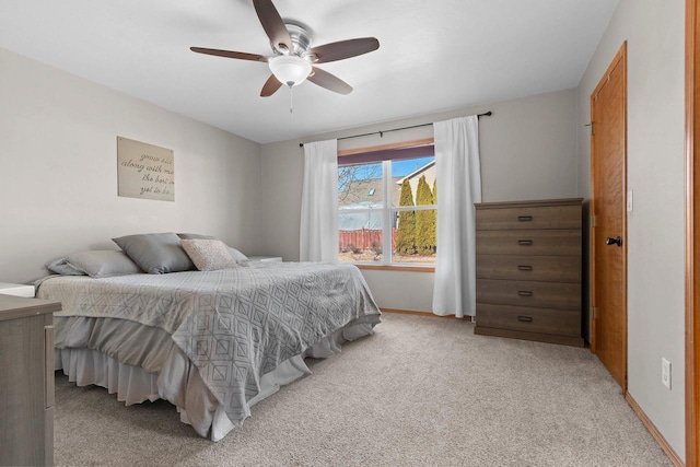 bedroom with ceiling fan, baseboards, and light carpet