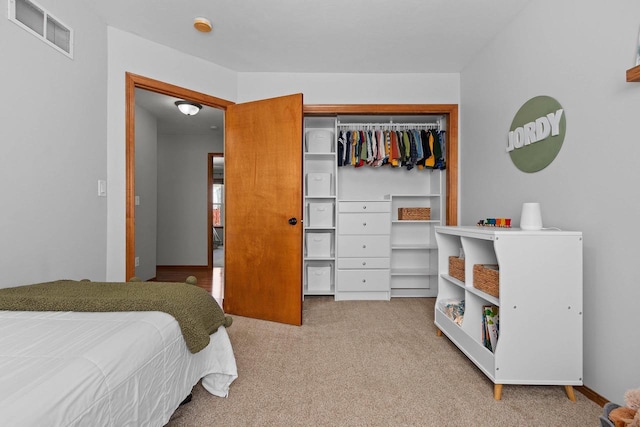 bedroom with visible vents, carpet floors, and a closet